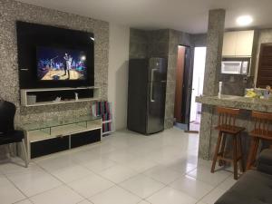 uma sala de estar com uma televisão na parede em Casa PRAIA DE CARAPIBUS PB- TEMPORADA em João Pessoa