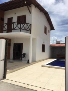 若昂佩索阿的住宿－Casa PRAIA DE CARAPIBUS PB- TEMPORADA，一座白色的房子,前面设有一个游泳池