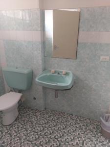 uma casa de banho com um lavatório, um WC e um espelho. em West End Motel em Adelaide
