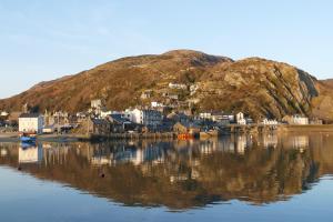 a small town on a hill next to a body of water at Bae Abermaw Boutique B&B in Barmouth