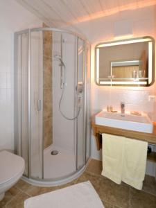ein Bad mit einer Dusche und einem Waschbecken in der Unterkunft Gästehaus Sonnenhang in Reit im Winkl