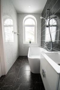 a bath tub sitting next to a window in a bathroom at Very Bad Hootel in Kaunas