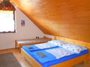 Cama en habitación con techo de madera en apartman-kata en Fertőd