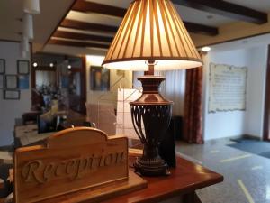 a lamp sitting on a table next to a restaurant sign at Pensiunea Floarea Soarelui in Braşov