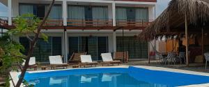 um resort com piscina e cadeiras e um edifício em VidaMar em Los Órganos