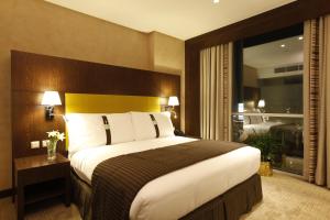 a hotel room with a bed and a large window at Holiday Inn Meydan, an IHG Hotel in Riyadh