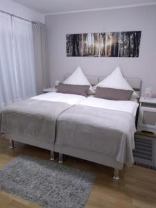 a bedroom with a large bed with white sheets at Ferienwohnung Altstadt in Rottenburg