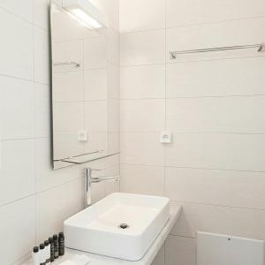 a white bathroom with a sink and a mirror at Ch apartment's Mykonos in Ornos +14 photos