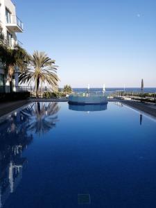 a large blue swimming pool next to a building at Coralli Superior Seaview in Protaras