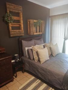 a bedroom with a bed with pillows on it at A-Cody Place in Louis Trichardt