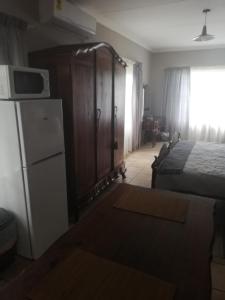 a bedroom with a bed and a refrigerator and a bed at A-Cody Place in Louis Trichardt