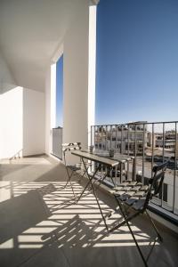 een tafel en stoelen op het balkon van een gebouw bij Alinea Suites Limassol Center in Limassol