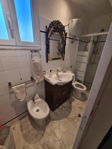 ein Badezimmer mit einem Waschbecken, einem WC und einem Spiegel in der Unterkunft La Casa di Marcello in Torre Annunziata