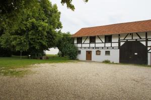 une grange blanche avec un toit rouge et une cour dans l'établissement Gasthof Rundeck, 