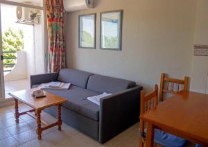a living room with a couch and a table at Apartments Kione Playa Romana Park in Alcossebre