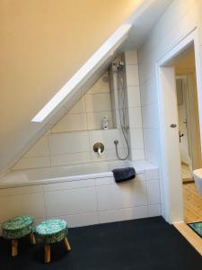 a bathroom with a bath tub and two stools at Ferienwohnung 3 zwischen Nürnberg und Regensburg in Deining