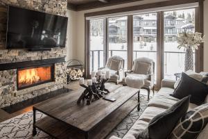 een woonkamer met een open haard en een houten salontafel bij Gateway Condo - 15 Wildwood in Big Sky