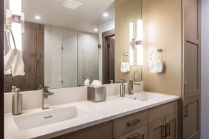 een badkamer met twee wastafels en een grote spiegel bij Gateway Condo - 15 Wildwood in Big Sky +17 foto's