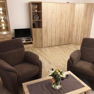 uma sala de estar com duas cadeiras e uma mesa de centro em Haus Niemann em Wyk auf Föhr