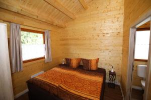 1 dormitorio con 1 cama en una cabaña de madera en Hotel Grünes Paradies, en Hochwaldhausen