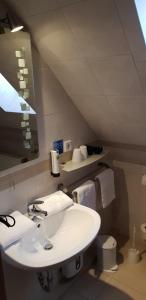 a white bathroom with a sink and a mirror at Airport Hotel One Aparthotel Sylt in Tinnum +28 photos