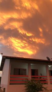 a house with a cloudy sky above it at Atma Anna in Piedade