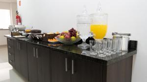 um balcão de cozinha com uma taça de frutas e copos em Hotel Carmelo em São José dos Pinhais