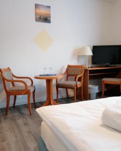 a hotel room with a table and chairs and a tv at Landidylle in Wohlenhagen