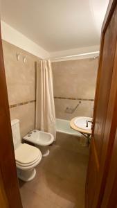 a bathroom with two toilets and a sink and a tub at Samay Huasi - 3 dorm en suite - inmejorable ubicación - cochera cub in San Martín de los Andes