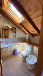 a bathroom with two toilets and two sinks and a skylight at Samay Huasi - 3 dorm en suite - inmejorable ubicación - cochera cub in San Martín de los Andes
