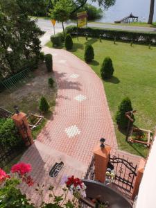 a brick walkway in a park next to the water at Gościniec LECH in Kosewo