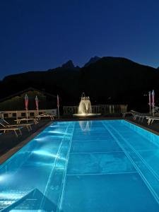ein Schwimmbad in der Nacht mit einem Brunnen in der Unterkunft Gästehaus Obersulzberglehen in Schönau am Königssee