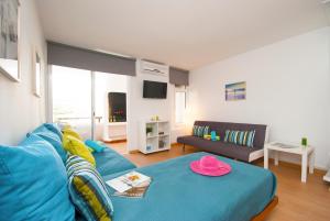 ein Wohnzimmer mit einem blauen Sofa und einem Tisch in der Unterkunft Apartment Studio Marbella by Algarve Vacation in Albufeira