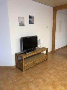 a flat screen tv sitting on a wooden stand in a room at Ferienwohnung Jasmin in Haiger
