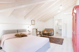 1 dormitorio blanco con 1 cama y 1 silla en Villa Trisano, en Bra