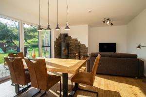 a dining room with a table and a couch at Haus am See - Ferienwohnungen in Neukirch