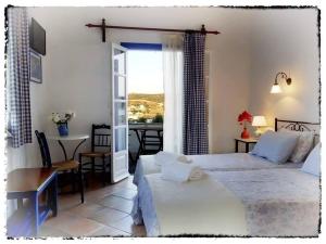 a bedroom with a bed and a dining room with a table at Sevasti Rooms in Platis Gialos