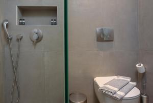 a shower stall in a bathroom with a toilet and a shower at Vigla Hotel in Aegiali