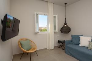 a living room with a blue couch and a window at Vigla Hotel in Aegiali