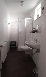 a bathroom with a toilet and a sink and a shower at Gästehaus bed & kitchen in Schleswig