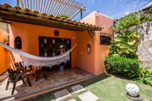 a house with a hammock in the yard at Pousada Tranquilandia Village in Canoa Quebrada