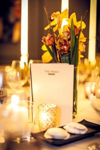 een tafel met een witte kaart en een vaas met bloemen bij Villa Medici in Münster