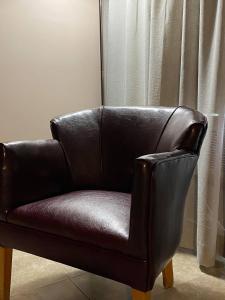 a brown leather chair sitting in front of a window at Motel Le Martinet in La Pocatiere