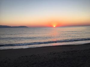 - un coucher de soleil sur l'océan et une plage dans l'établissement Anesis Hotel, à Agía Pelagía