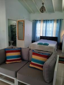 a living room with a couch and a bed at CC Best Villas Tobago in Lowlands