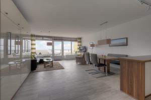a living room with a table and a dining room at Christiansen im Panoramahaus Duhnen in Cuxhaven +72 photos