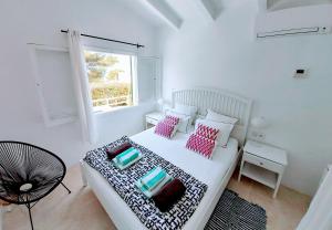 - une chambre blanche avec un lit et une fenêtre dans l'établissement Ty Bihan, à Sant Lluis