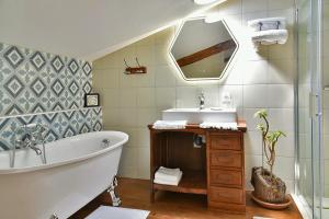 Un baño con bañera, lavabo y espejo. en Domaine de Garat, en Floirac 49 fotos más