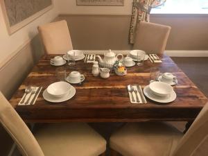 a wooden table with white plates and silverware on it at The White Pheasant in Lenwade