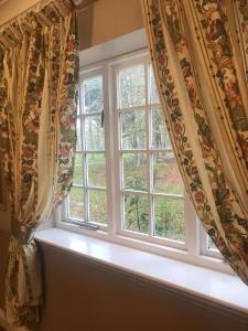 una ventana con cortinas en un alféizar blanco en The White Pheasant, en Lenwade